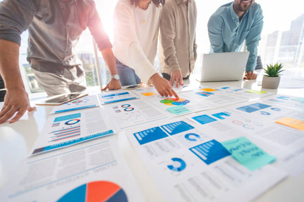 istock Multi racial group of people working with Paperwork on a board room table at a business presentation or seminar 1366844843