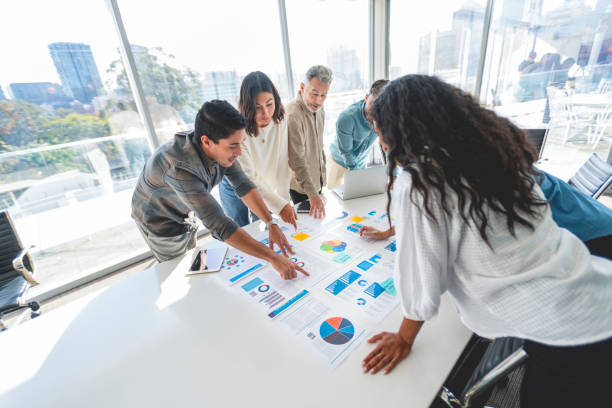 istock Diverse group of people working with Paperwork on a board room table at a business presentation or seminar. 1366844845