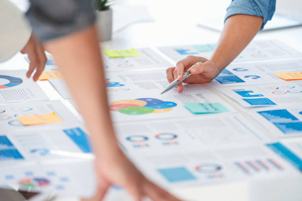 istock Multi racial group of people working with Paperwork on a board room table at a business presentation or seminar. 1366844846