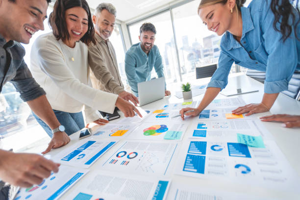 istock Multi racial group of people working with Paperwork on a board room table at a business presentation or seminar 1366844847