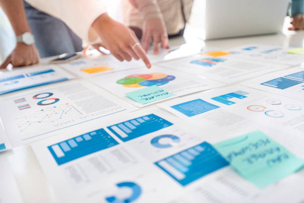 istock Multi racial group of people working with Paperwork on a board room table at a business presentation or seminar. 1366844849
