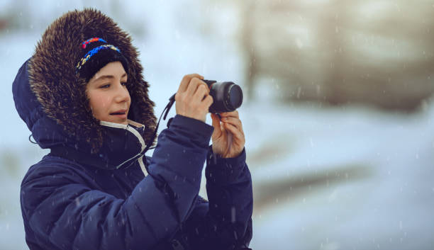 istock Young Female Taking Pictures in Snowfall 1366845692