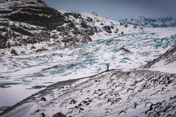 Active Life. Traveler Woman with Raised Up Hands Enjoying Beauty of Nature. Happy Winter Vacation. Solheimajokull. Iceland.