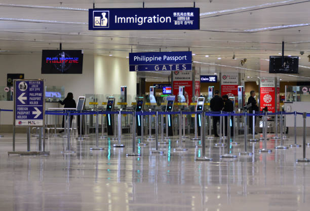 Immigration passport control point at Ninoy Aquino International Airport, Manila, Philippines Manila, Philippines: Immigration passport control point - Ninoy Aquino International Airport / Manila International Airport - self service automated control gates - E-gates - retractable queue management ribbons. NAIA stock pictures, royalty-free photos & images