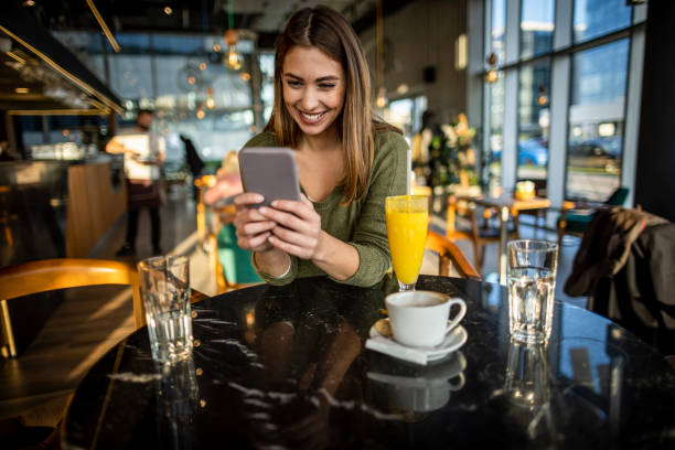 istock Beautiful woman with smart phone in cafe 1366847193