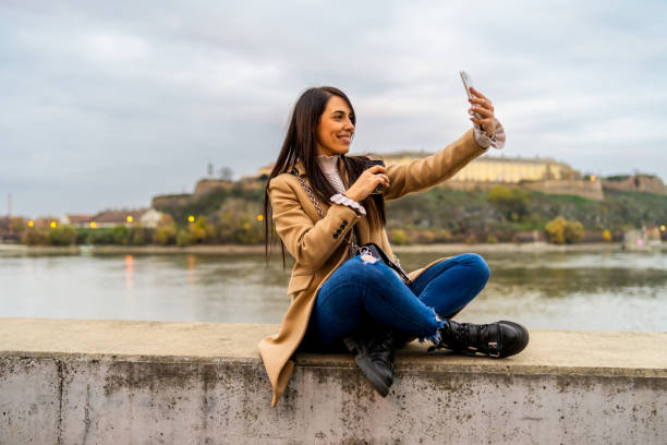 istock Woman taking selfie with her smartphone and drinking coffee takeaway 1366847896
