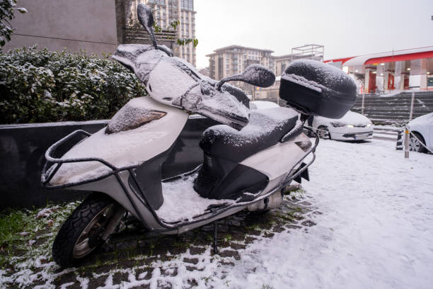 冬の大雪の後に雪に覆われた駐車オートバイ - car ice motor scooter sign ストックフォトと画像