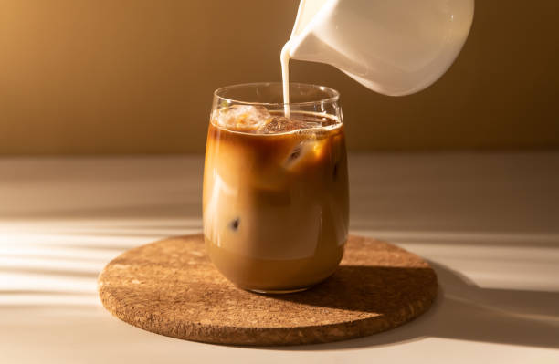 istock Milk cream is poured into a iced cold brew coffee. 1366850537