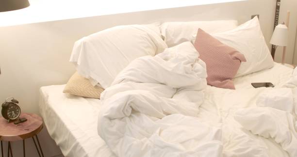 istock Bedroom interior in morning. A bed with blankets and pillows. Phone is on sheet. 1366851555