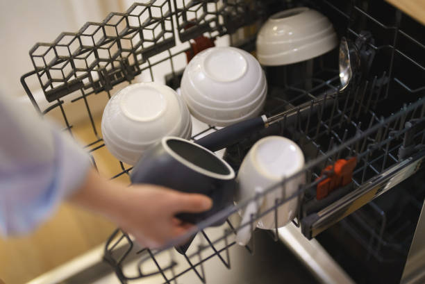istock Woman unloads dishes from the dishwasher. 1366851557
