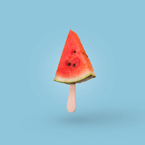 istock Watermelon slice on a ice cream stick isolated on bright blue background. 1366851874