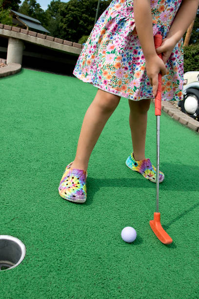 ミニゴルフで遊ぶ小さな女の子 - round toe shoes ストックフォトと画像