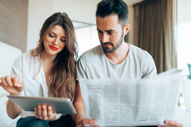 istock couple reading the newspaper on the hotel 1366861715