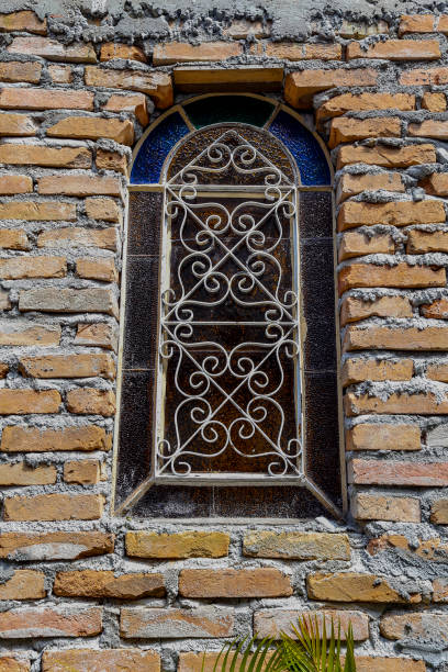 istock Old stained glass on the apparent brick wall 1366862674