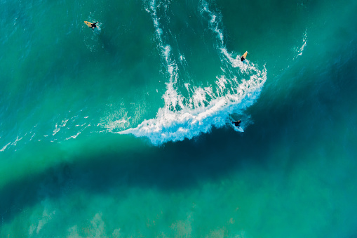 Surfer ride on surfboard on wave in ocean. Aerial view in Brazil