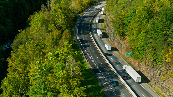 Aerial shot of Interstate 40 on the banks of the Pigeon River beneath the thickly wooded slopes of the Appalachian Mountains in the Pisgah National Forest, North Carolina.