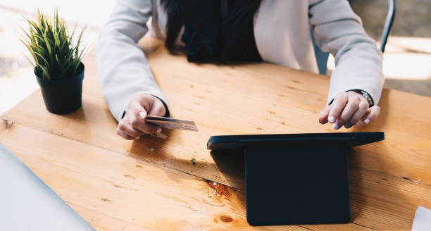 istock Online payment,woman's hands holding a credit card and using laptop computer for online shopping with vintage filter tone 1366882260