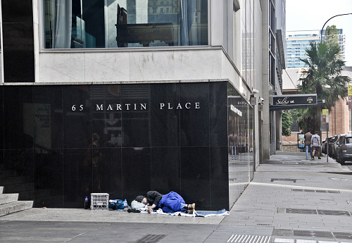 Sydney, Australia - April 14, 2019: Reserve Bank of Australia at 65 Martin Place on black granite wall in Sydney Australia with a homeless man sleeps nearby