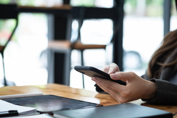 istock Close up woman using mobile phone on workplace 1366883076