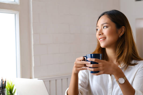 istock Beautiful woman using laptop at cafe while drinking coffee. 1366887372