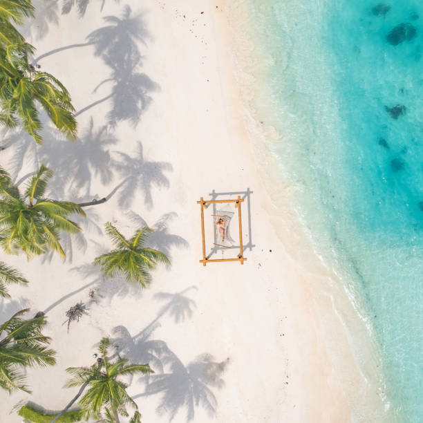Aerial view of a woman lying on a hammock on the beach stock photo