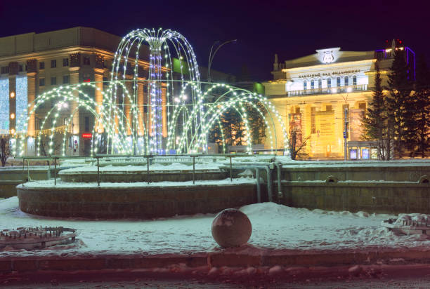 Novosibirsk, Siberia, Russia, 01.16.2022. Fountain in the winter city. The buildings of the City Hall and the \