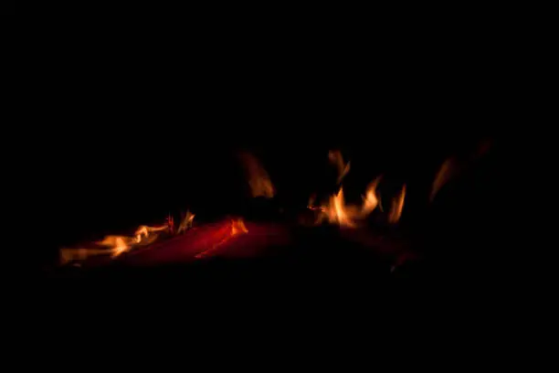 Flames and glowing embers as fire dies in woodstove