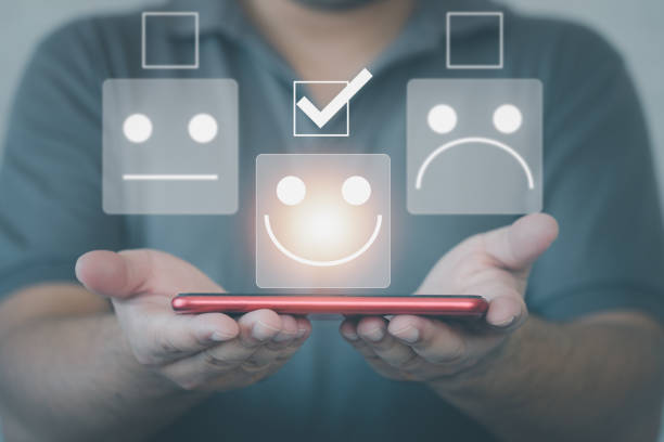 istock Man showing smartphone choosing happy smiley face icon. Feedback rating 1366894384