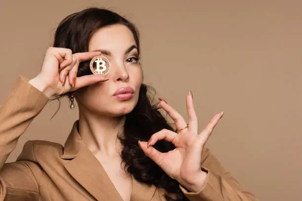 Photo of Woman showing golden bitcoin