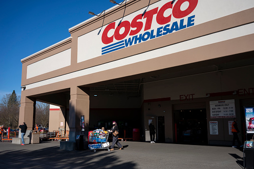 Aloha, OR, USA - Jan 25, 2022: A shopper walks out of the Costco Wholesale store in Aloha, Oregon, with a full shopping cart. After years of low inflation, the U.S. is seeing surging consumer prices.