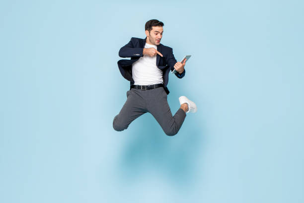 istock Caucasian businessman with tablet jumping 1366899728