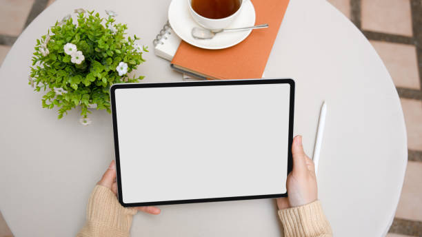 istock Overhead shot, Female using digital tablet over outdoor coffee table. 1366905514