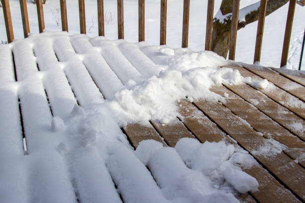 istock Partially shoveled snow designs on a wooden deck 1366907925