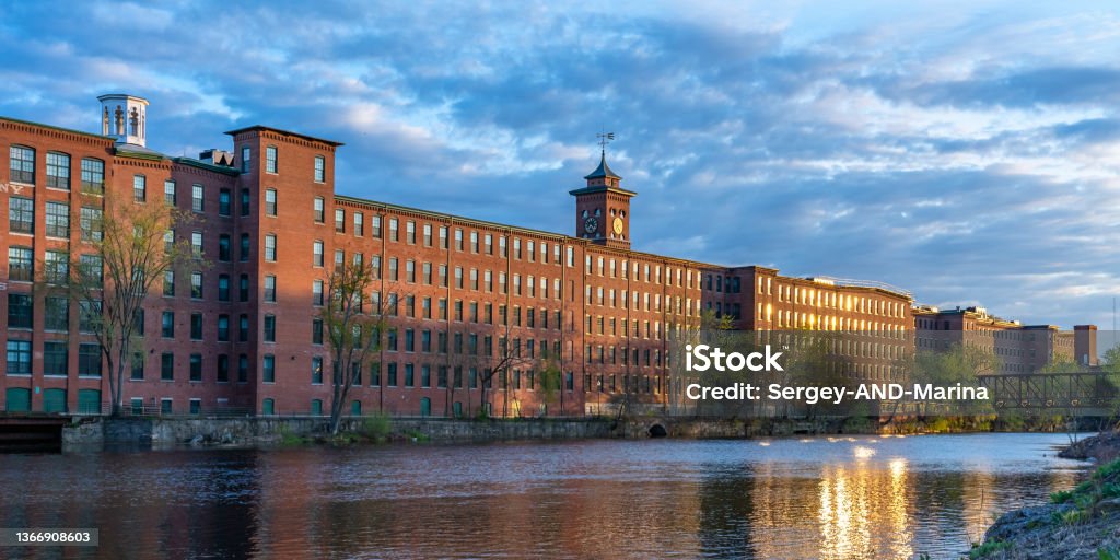 Sunset in Nashua. Historic cotton mill building with clock tower in Nashua Old Industrial Park Sunset in Nashua. Historic cotton mill building with clock tower in Nashua Old Industrial Park. Nashua Corporation. Nashua Manufacturing Company, New Hampshire, USA New Hampshire Stock Photo