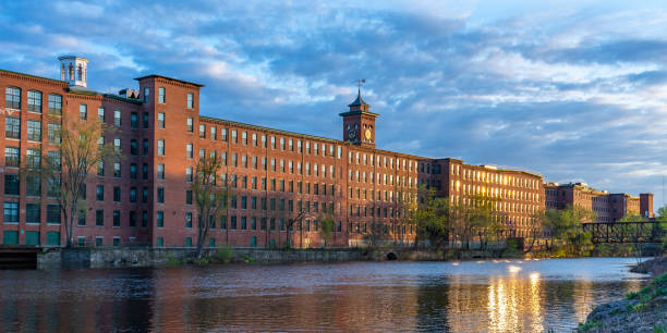 Sunset in Nashua. Historic cotton mill building with clock tower in Nashua Old Industrial Park Sunset in Nashua. Historic cotton mill building with clock tower in Nashua Old Industrial Park. Nashua Corporation. Nashua Manufacturing Company, New Hampshire, USA nashua new hampshire stock pictures, royalty-free photos & images