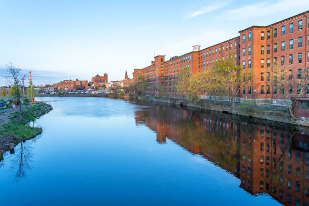 Nashua River in May. Nashua River in May. On the shore there is a historical building of a cotton factory with a clock tower in an old industrial park. Nashua, New Hampshire, USA nashua new hampshire stock pictures, royalty-free photos & images