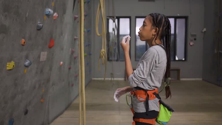 Young Indonesian Teenage Girl Applying Chalk Preparing To Rock Climb