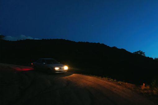 Car driving down country road at night
