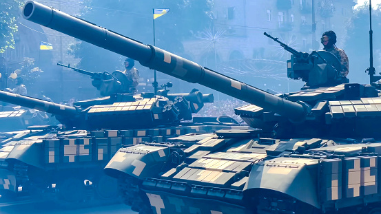 A line of tanks headed to battle, with a blue sky overhead available for copy space.