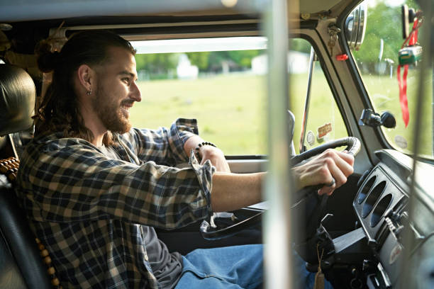 istock Smiling late 20s Hispanic man driving van on road trip 1366915942