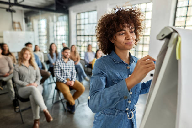 istock Smiling female leader writing plans on a seminar. 1366921298
