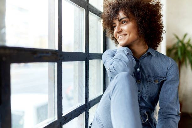 istock Happy woman day dreaming by the window. 1366921412
