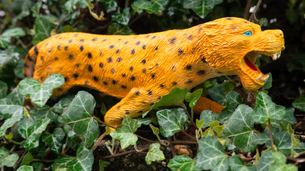 istock Leopard plastic toy in creeping leaves. 1366922587