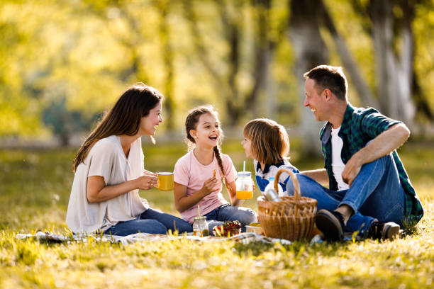 istock Happy parents and their small kids communicating during picnic in springtime. 1366922766