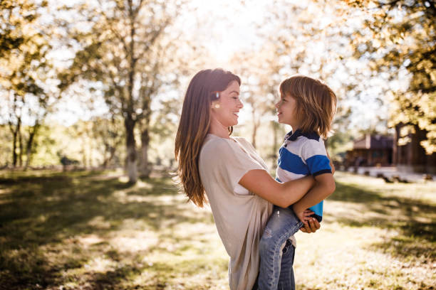 istock Happy single mother talking to her son in the park. 1366923080