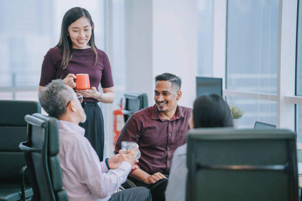 istock Group of Asian white collar worker having a break taking snack at the workstation office together 1366924109