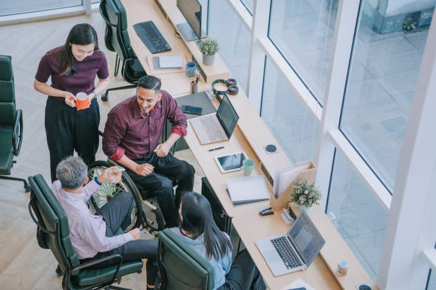 istock Group of Asian white collar worker having a break taking snack at the workstation office together 1366924126