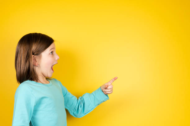 istock Surprised girl pointing to copy space 1366924618