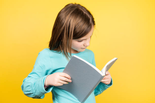 istock Little girl reading a book 1366924691