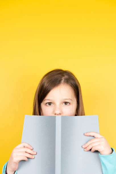 istock Child holding book and looking to camera 1366924701